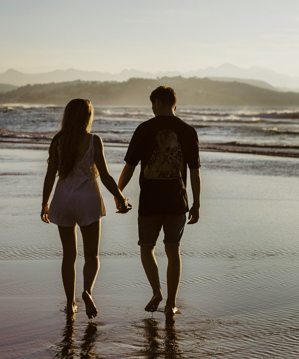 Couple walking hand in hand on a beach